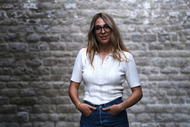 Mujer de moda joven mirando mientras posa para la cámara en una calle de Barcelona