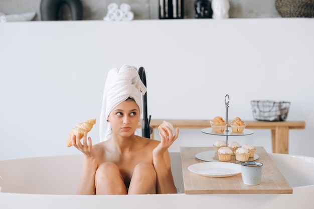 Mujer de moda de lujo en la mañana tomar el desayuno tumbado en el baño