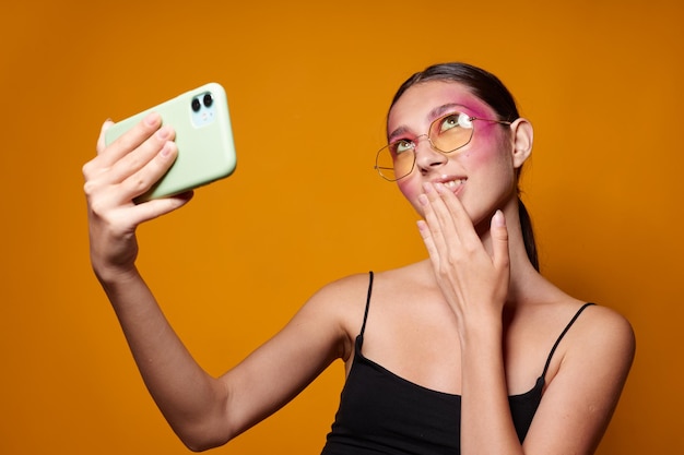 Mujer de moda mira el teléfono maquillaje brillante posando emociones de moda vista recortada inalterada