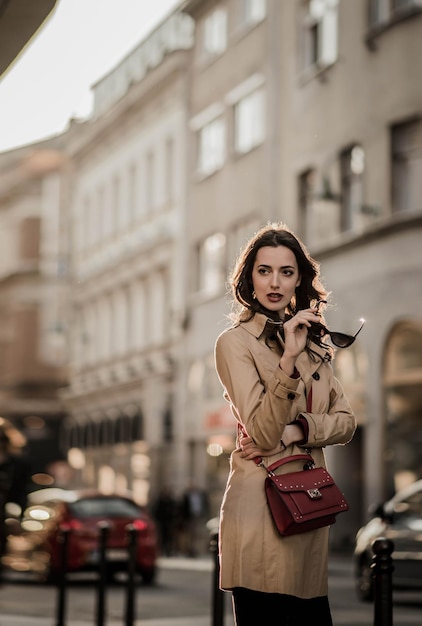 Mujer de moda de pie contra un edificio en la ciudad