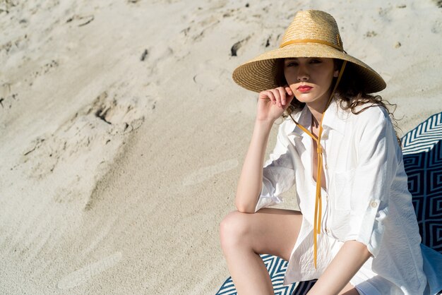 Mujer de moda en la playa soleada
