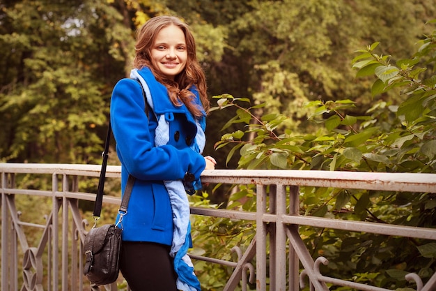 Mujer de moda en el puente en el parque otoño