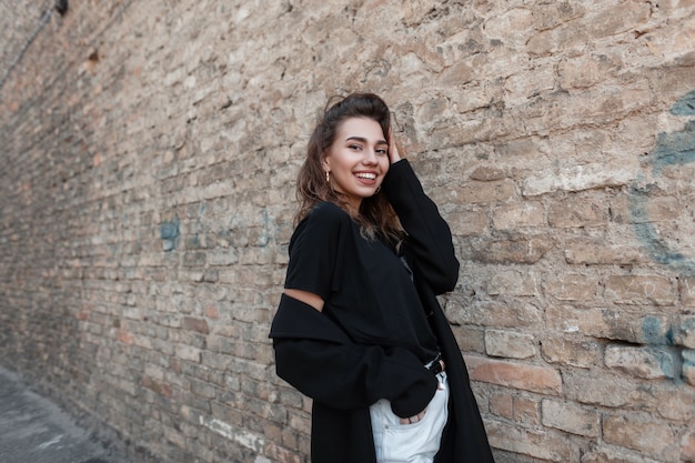 Mujer de moda en ropa negra camina por la calle