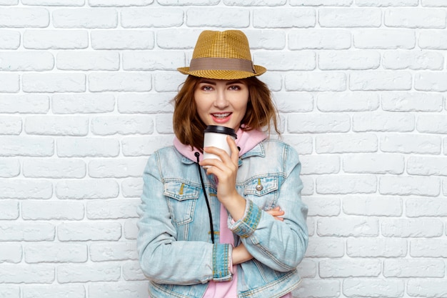 Mujer de moda sonriente que bebe el café