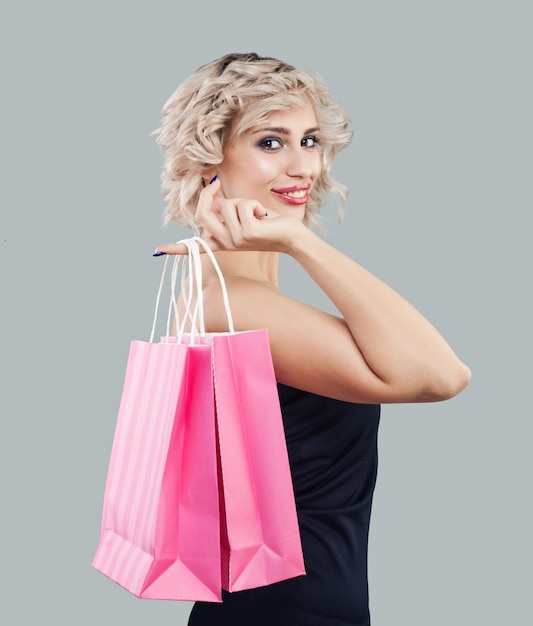 Mujer modelo feliz con bolsa de compras rosa