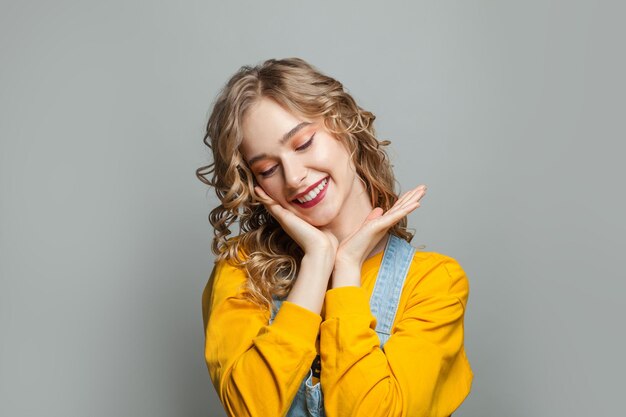 Mujer modelo feliz sonriendo sobre un fondo gris