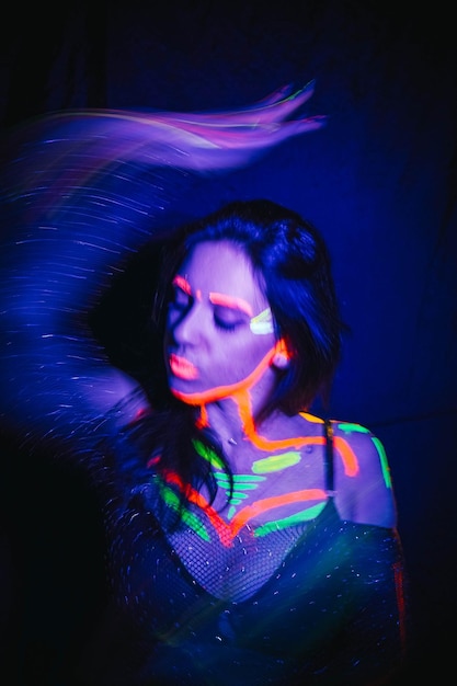 Mujer modelo en luz de neón chica hermosa modelo con diseño de arte de maquillaje fluorescente de bailarina de discoteca bailando en maquillaje colorido con luz ultravioleta Nightclub Party 4K video