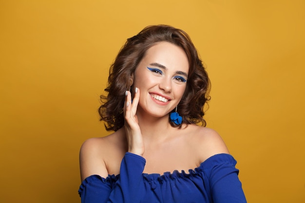 Foto mujer modelo de moda encantadora sonriendo sobre un fondo amarillo