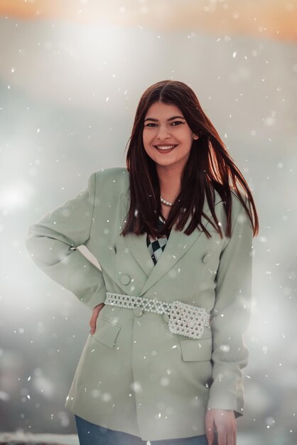 Una mujer moderna con una chaqueta verde posando afuera.