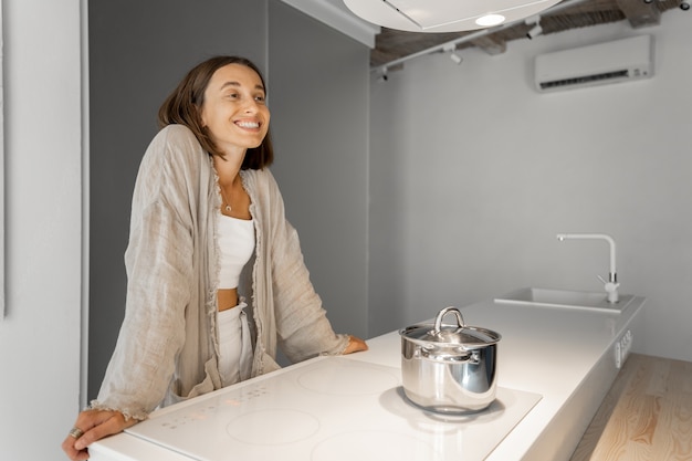 Mujer en la moderna cocina blanca en casa