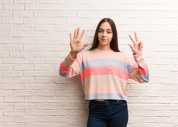 Mujer moderna joven que muestra el número ocho