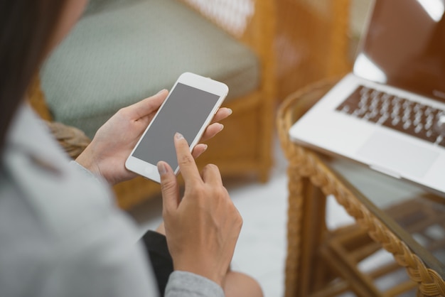 Mujer moderna del lugar de trabajo que usa el teléfono móvil en oficina.