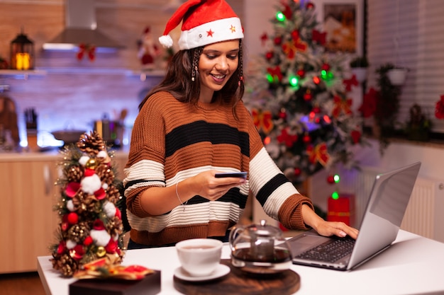 Mujer moderna pagando regalos con tarjeta de crédito