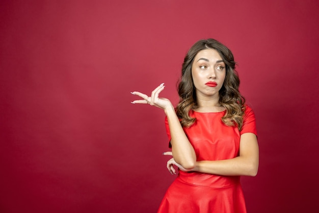 Mujer molesta mirando desdeñosamente sobre un fondo rojo.