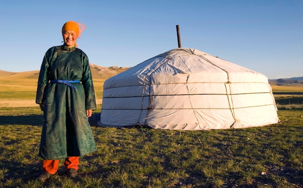 Foto mujer de mongolia de pie delante de un ger