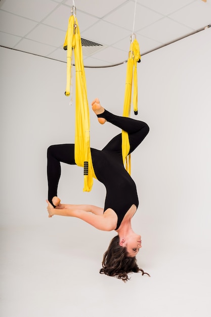 Una mujer con un mono deportivo hace ejercicios de yoga al aire