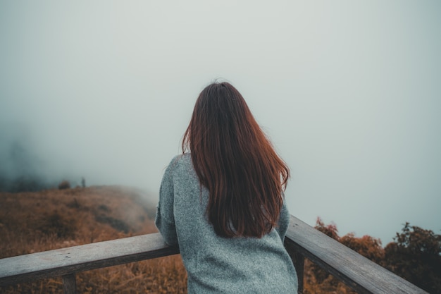 Mujer en la montaña con niebla