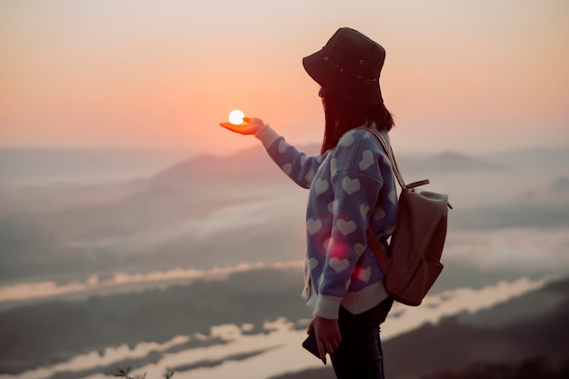 mujer en una montaña con sol