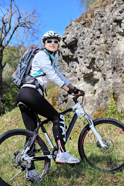 Foto mujer montando en bicicleta en la montaña