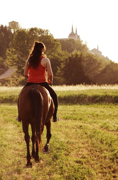 Mujer montando a caballo en el campo