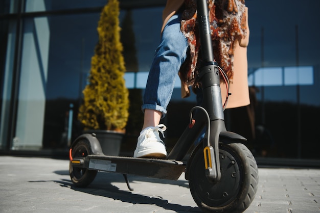 Mujer montando un scooter eléctrico al aire libre