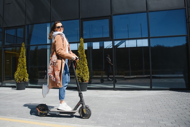 Mujer montando un scooter eléctrico al aire libre