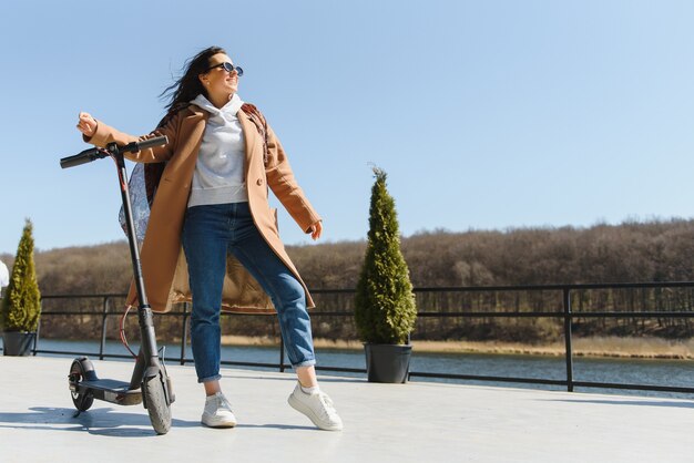 Foto mujer montando un scooter eléctrico al aire libre