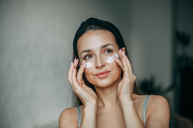 Foto mujer morena de 30 años con crema en la cara