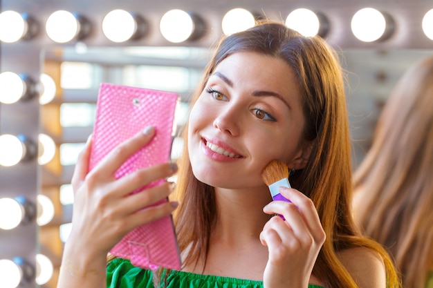 Mujer morena aplicando maquillaje para una cita nocturna
