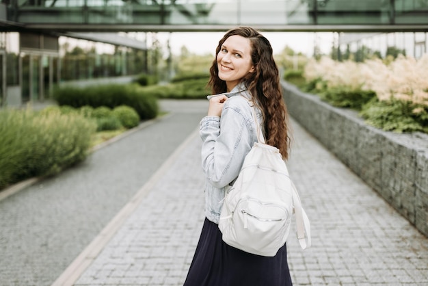 Mujer morena bastante joven feliz con mochila