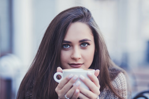 Mujer morena bebiendo cafe