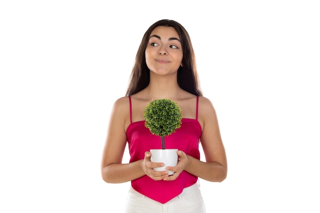 Mujer morena de belleza con un pequeño árbol verde