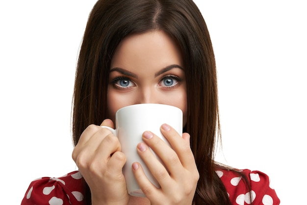 Mujer morena caucásica con taza de café aislado sobre fondo blanco.