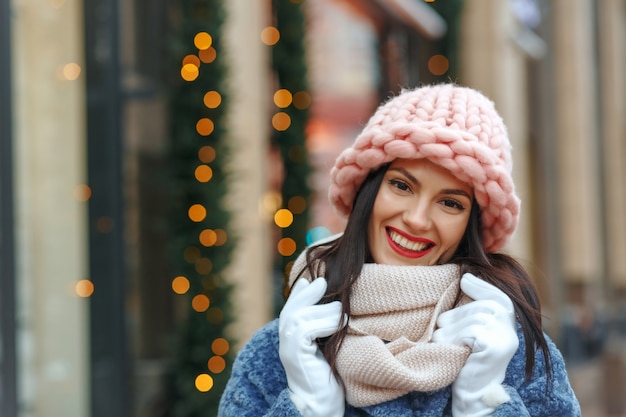 Mujer morena con clase en abrigo caminando en la ciudad en invierno. Espacio vacio