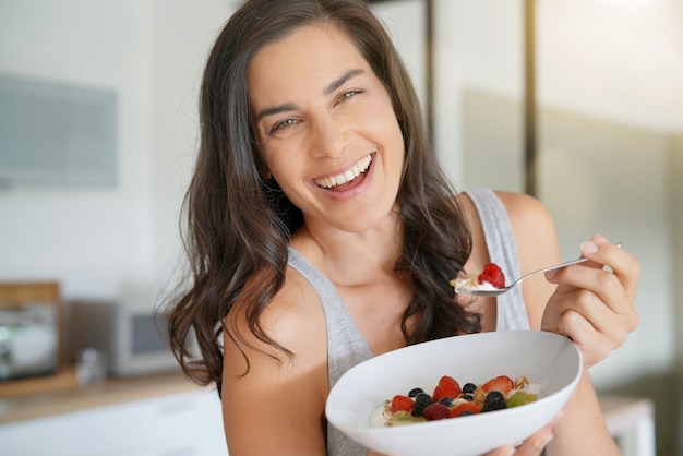 Mujer morena desayunando saludable en casa