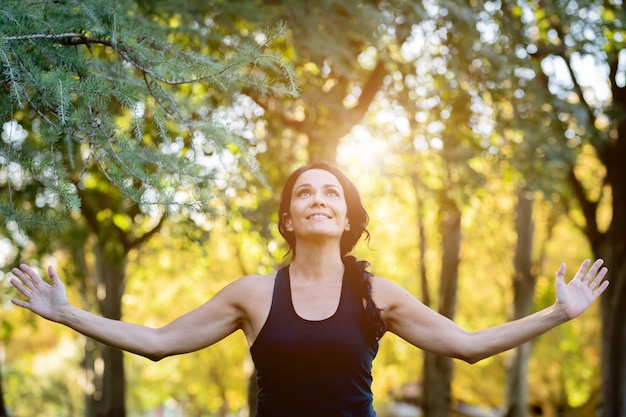 Mujer morena haciendo yoga en un parque