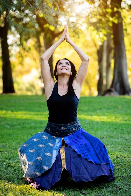 Mujer morena haciendo yoga en un parque