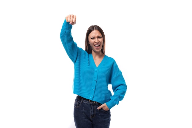 Mujer morena joven y bien cuidada vestida con un cardigan azul sobre un fondo blanco con espacio de copia