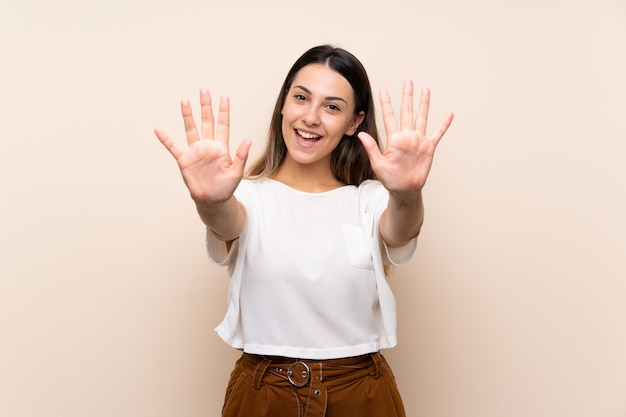 Mujer morena joven que cuenta diez con los dedos