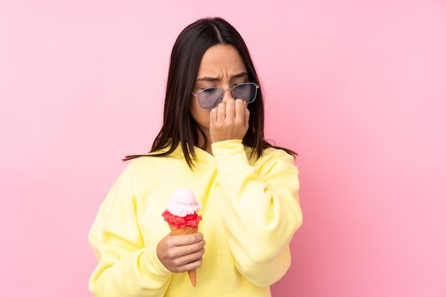 Mujer morena joven que sostiene un helado de cucurucho que tiene dudas