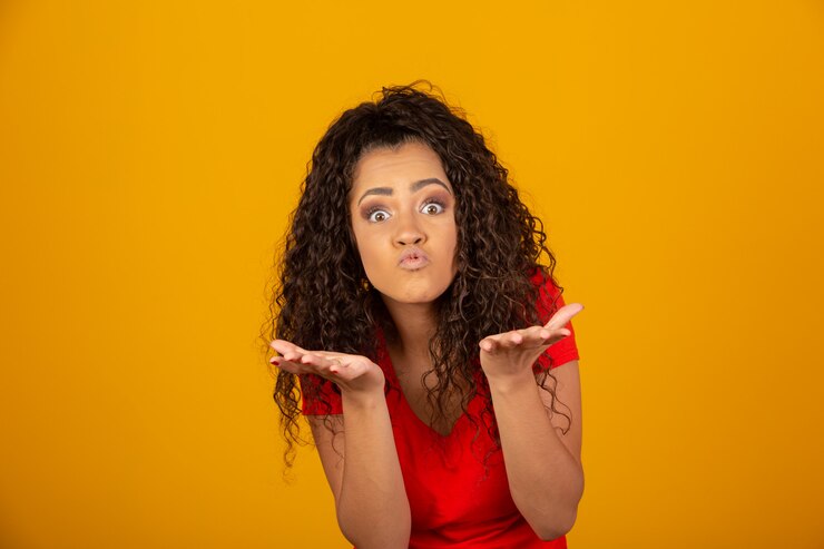 Foto mujer morena con largo y brillante cabello rizado enviando beso