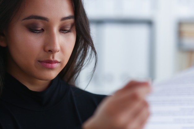 mujer morena leyendo un documento