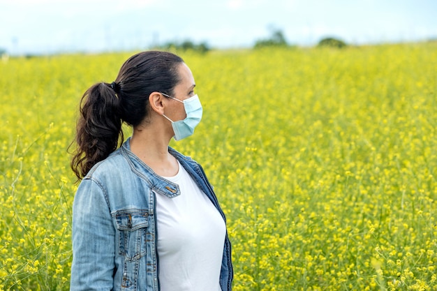 Mujer morena con una máscara en el campo