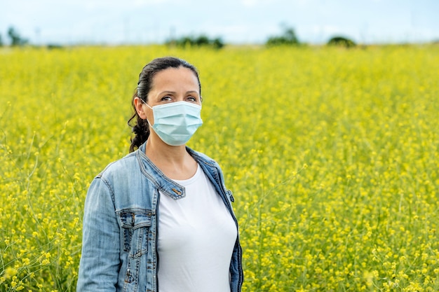 Mujer morena con una máscara en el campo