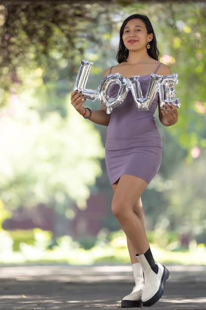 Mujer morena mexicana con letras de globos de amor día de san valentín día de la mujer