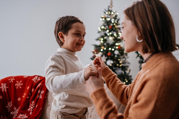 Mujer morena mirando a su hijo con una sonrisa tierna mientras celebra el Año Nuevo en casa