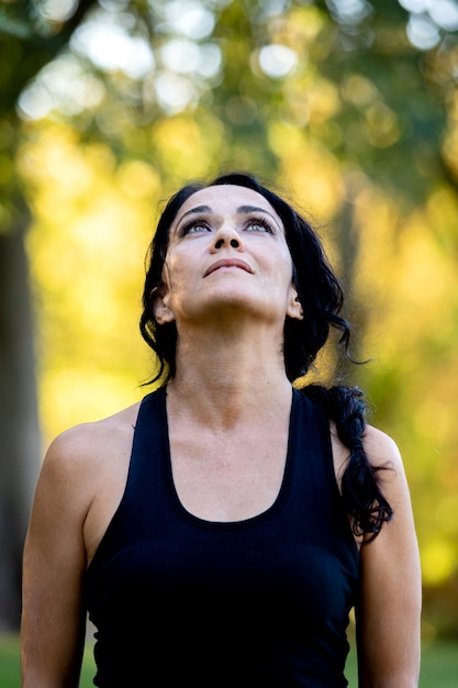 Foto mujer morena pensativa que se alegra un día en un parque