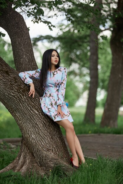 Mujer morena en las ramas de un hermoso árbol floreciente.