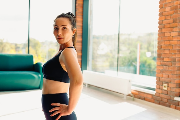 Mujer morena. Saludable, atlético con una hermosa asana, en el gimnasio durante el entrenamiento. Foto con espacio lateral vacío.