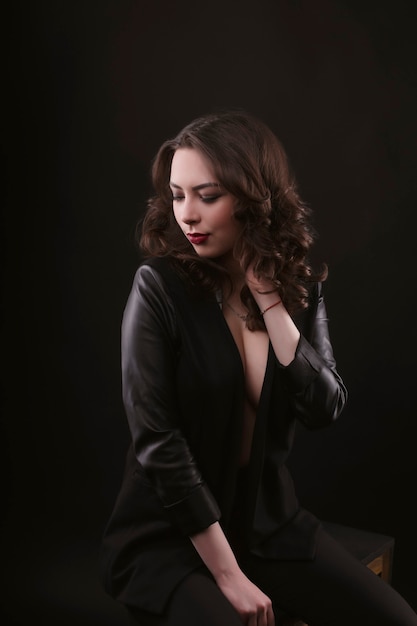 Mujer morena sexy en chaqueta de cuero en el estudio